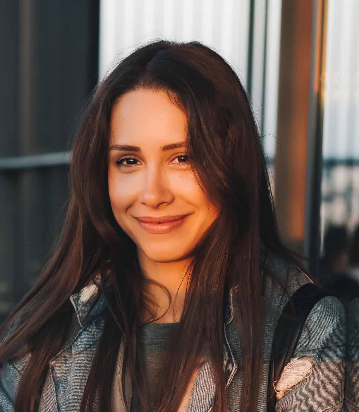 Portrait of a young attractive emotional girl dressed in a trendy blue denim coat